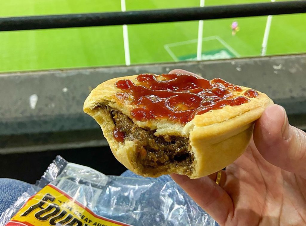 Iconic Aussie foods: meat pie with sauce at the footy